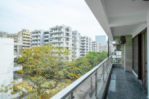a balcony of a building with trees and buildings at FlxHo Corporate - Golf Course Road in Gurgaon