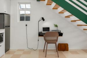 a room with a desk with a computer underneath a staircase at Neighbourgood Franschhoek in Franschhoek