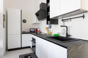 a kitchen with white cabinets and a sink at Ali'S rooms and apartments in Càbras +15 photos
