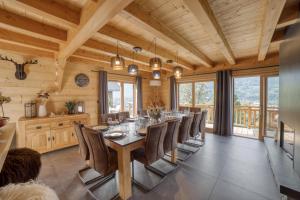 una sala da pranzo con un lungo tavolo e sedie di Chalet****Luxe Sauna & SPA Le Champenois a Samoëns