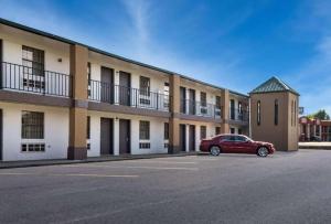 Un coche rojo aparcado delante de un edificio en Quality Inn Brownsville, en Brownsville