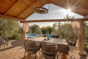 a patio with a table and chairs and a pool at House with pool, 50 meters from sea, privacy - by TRAVELER tourist agency Krk - ID 2137 in Kornić
