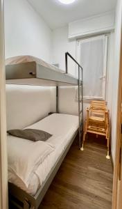 a bunk bed in a small room with a chair at CASA MIKI in Rapallo