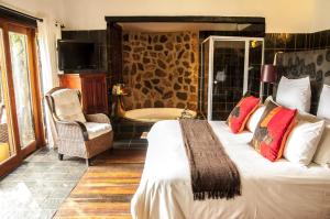 a hotel room with a bed and a chair at Kedar Heritage Lodge, Conference Centre & Spa in Phokeng