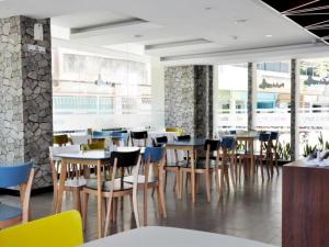 a dining room with tables and chairs in a restaurant at Nite and Day Batam Jodoh Square in Nagoya
