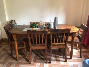 a wooden dining room table with chairs and a table at Micasa Apartment in Bālāju