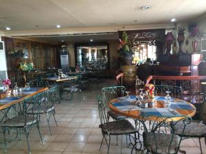a restaurant with tables and chairs and a piano at Pearlmont Hotel in Camaman