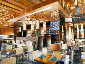 a restaurant with wooden ceilings and tables and chairs at Dezhou Regal Kangbo Hotel in Dezhou