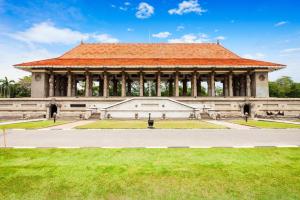 a large building with an orange roof on a field at Sai Sea City Hotel in Colombo