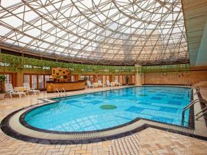 a large swimming pool with a glass ceiling at Wuhan Premier Mayflowers Hotel in Wuhan
