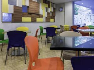 a dining room with colorful chairs and tables at Hotel New Coklat in Surabaya