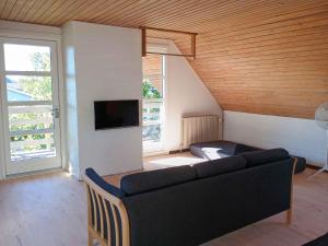 a living room with a couch and a tv at Family-Friendly Home Near Beach, Forest, Harbour in Ålbæk