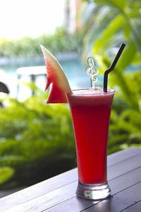 a red drink in a glass on a table at Eclipse Hotel Prawirotaman in Yogyakarta