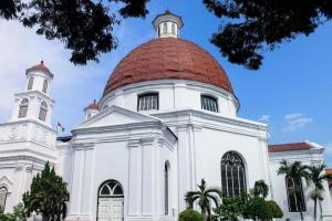 a large white building with a red dome at Muria Hotel in Semarang