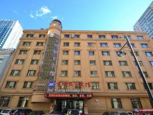 a large building with a sign in front of it at Harbin Baixiang Holiday Hotel in Harbin