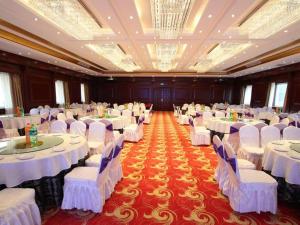a large banquet hall with white tables and chairs at Harbin Baixiang Holiday Hotel in Harbin