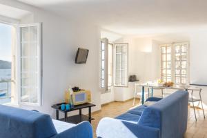 Una sala de estar con dos sofás azules y un televisor. en Résidence Partenaire Le Palais de la Marine, en Villefranche-sur-Mer