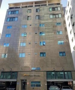 a tall building with cars parked in front of it at Novalus Tourist Hotel in Seoul
