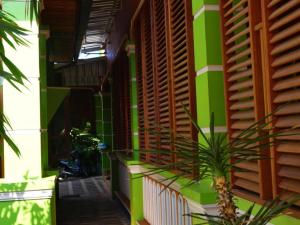 a building with green and wooden shutters on it at Phetphaylin Hotel in Ban Talai