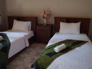 two beds sitting next to each other in a room at Phetphaylin Hotel in Pakse +46 photos