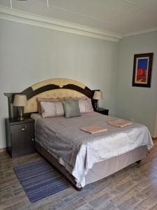 a bedroom with a large bed with two night stands at De la Rose Guesthouse in Lephalale +99 photos
