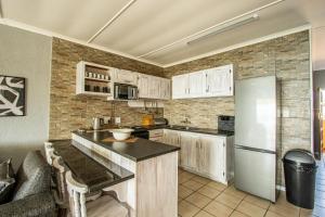 a kitchen with white cabinets and a refrigerator at Summer Place 12 in Shelly Beach