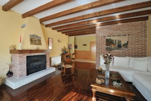 sala de estar con sofá y chimenea en Hotel Rural y Restaurante, Rinconcito de Gredos, en Cuevas del Valle