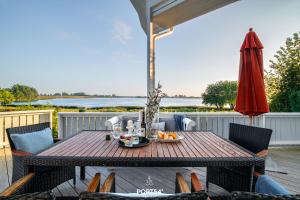a table on a deck with an umbrella at Ferienhaus BREEZE 71 Kappeln in Kappeln