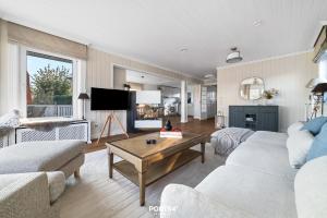 een woonkamer met een bank en een tafel bij Ferienhaus BREEZE 71 Kappeln in Kappeln +36 foto's