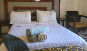 Un dormitorio con una cama con toallas. en Quest, en Lilongwe