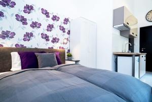 a bedroom with a bed with purple pillows at Modern Intimate Studio in the center in Budapest