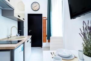 a kitchen with a sink and a clock on the wall at Modern Intimate Studio in the center in Budapest