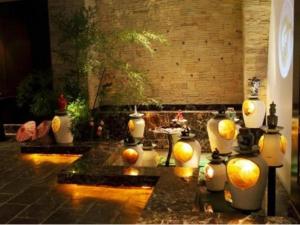 a group of vases with oranges in a room at New Century Shaoxing Grand Hotel in Shaoxing