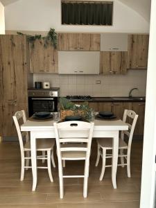 cocina con mesa blanca y sillas en Mariposa Suite, en Manfredonia 37 fotos más