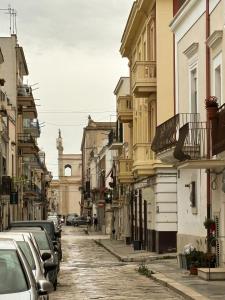 una calle de la ciudad con coches y edificios aparcados en Mariposa Suite, en Manfredonia