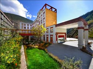 un grand bâtiment avec un pont au-dessus d'une allée dans l'établissement Ramada Encore, à Kanggar