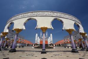 a large white building with arches in a courtyard at Horison Nindya Semarang in Semarang
