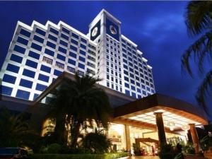 a large building with a clock tower at night at Fenggang Gladden Hotel in Tiantangwei