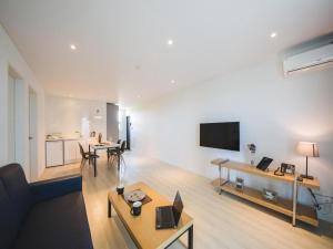 済州市にあるSallys Jeju Hotelのリビングルーム(ソファ、ノートパソコン付きテーブル付)