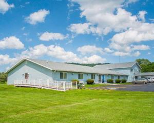 a large white building with a large yard at Econo Lodge Cuba I-86 in Cuba