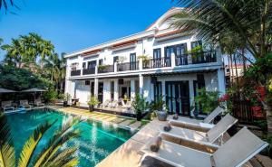 una villa con piscina di fronte a una casa di Mulberry Hotel a Siem Reap