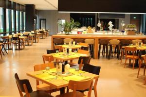 a restaurant with wooden tables and chairs and a bar at Intercity Hotel Qingdao in Huangdao
