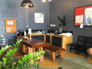 a restaurant with a table and benches in a room at Sritrang Hotel in Trang