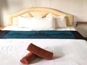 a close up of a bed with a towel on it at Sritrang Hotel in Trang