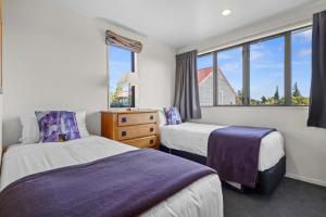 a hotel room with two beds and a window at *** LAKE VILLA 465 *** in Hanmer Springs