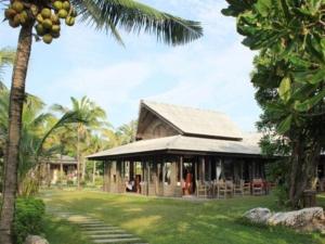 ein Resort mit einer Palme und einem Gebäude in der Unterkunft Chivaree Hotel and Resort in Chanthaburi