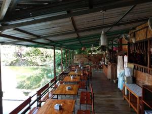 eine Reihe von Holztischen und -stühlen in einem Restaurant in der Unterkunft Phu Resort in Ban Choko