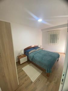 a bedroom with a bed and a window at Apartmani Kostić 