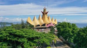 a large gold building with trees in front of it at Asoka Luxury Hotel in Bandar Lampung