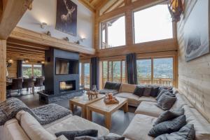 un soggiorno con divani e camino di Chalet****Luxe Sauna & SPA Le Champenois a Samoëns